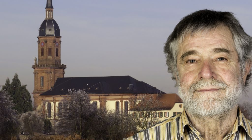Foto-Collage: rechts im Vordergrund Mann mit hellgrauem Vollbart und dunkelgrauen Haaren, im Hintergrund Katholische Kirche Schuttern